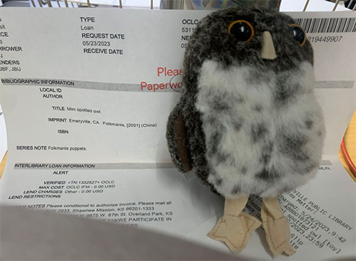 Stuffed owl toy sitting on Inter library Loan document