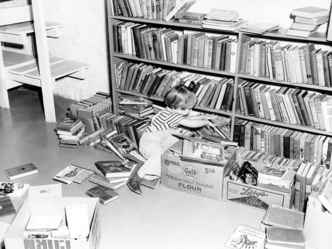 Lenexa Volunteer Library A child amid books during set-up of the Lenexa Volunteer Library circa 1954