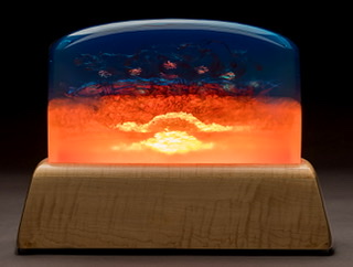 Resin sculpture with deep blue on top half and bright oranges on bottom.