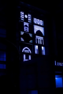 Night view of blue light behind decorative window patterns
