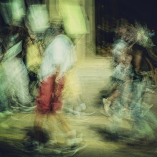 Blurred motion photograph of people walking the street.