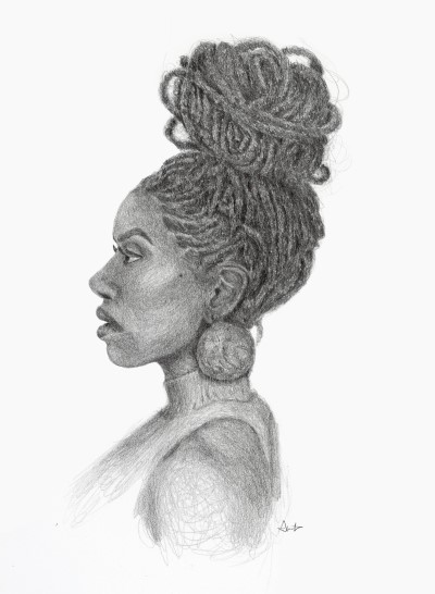 The profile of a black woman with her hair in braids and piled on top of her head in a top knot.