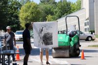 JCL makers added ink to a carved wood block to create a print with the help of a steamroller