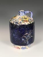 Stoneware jug covered in glazed floral and deep blue patterns.