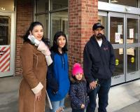 A family of four stands outside a Johnson County Library location