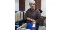 A HomeConnect volunteer fills a bag to send to a patron