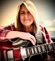 woman smiling with guitar