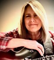 woman smiling with guitar