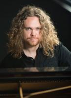 male with long curly hair smiling