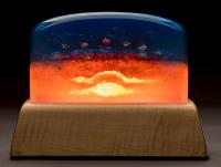 Resin sculpture with deep blue on top half and bright oranges on bottom half.