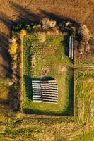 Aerial view of grassy field with hay bales.