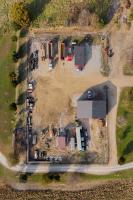Aerial view of rural dirt lot with trucks and two small buildings.