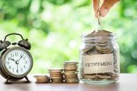 An alarm clock sits next to a jar labeled "retirement," filled with coins.