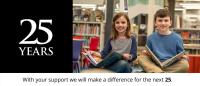 Two young people sit cross-legged on the floor with open books in their laps