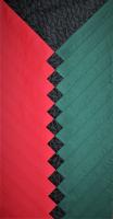 Textile panel made of red, black and green fabric creating a chevron pattern.