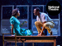 National Theatre Two actors face each other with lively expressions in a stage production of Small Island