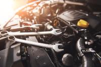 Wrenches sitting on the edge of a car's engine compartment