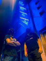 Friend and Stranger of Blood Daubers stand in front of a blue neon sign. *Photo credit: Brendan Henault