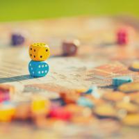 close up of dice on top of a game board with game pieces scattered around