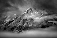 Black and white photograph of Grand Tetons with cloud cover at the summit.