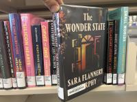 The book The Wonder State being pulled off a book shelf