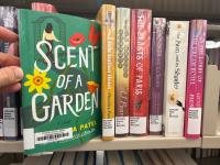 The Scent of a Garden by Namrata Patel being pulled out of a shelf of other books