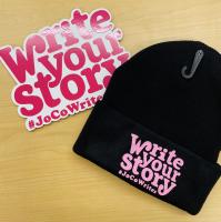 A black beanie hat and sticker that says "Write Your Story"