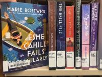 The book Esme Cahill Fails Spectacularly being pulled off of a shelf of books all with Library spine labels