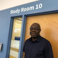 A person with glasses and a dark shirt stands outside the door of Study Room 10 at Central Resource Library