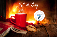 Photograph of an opened book upside down int front of a steaming coffee cup with a warm and cozy fire in the background.