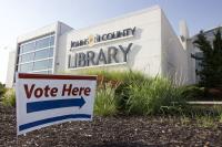 A sign saying "Vote Here" outside a Johnson County Library