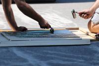 During Project Block & Roll, JCL makers add ink to a carved wood block to create a print