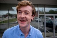 Jack Vandeleuv red-haired, smiling young man in a blue collared shirt