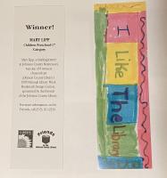 a photo of the front and back of a bookmark that says "I like the library" in blocks of marker color