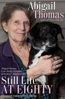 Older woman smiling and holding a black dog with white on his chest