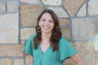 Lindsey Prewitt smiling woman with long brown hair, toiquoise blouse and large teardrop earrings