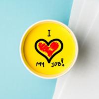A yellow circle with I love my job! written in side. The word love is replaced by a drawing of a heart.