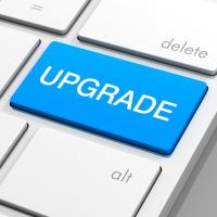 A blue button reading 'upgrade' on a computer keyboard